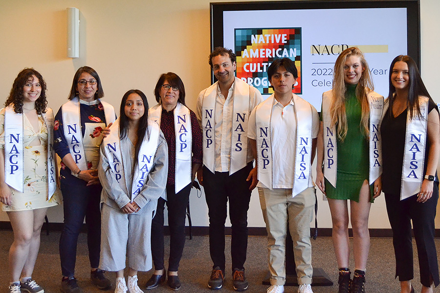 Students and professors pose for a group photo at a graduation event.