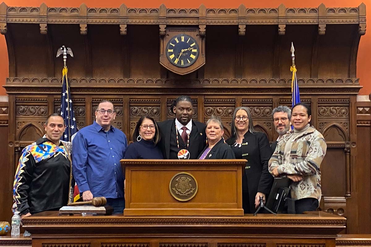A group of UConn faculty, alumni, and friend pose with the Larry Pemberton, center, in the Connecticut General Assembly.